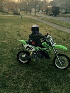a child with a dirt bike on the front lawn in Bloomfield