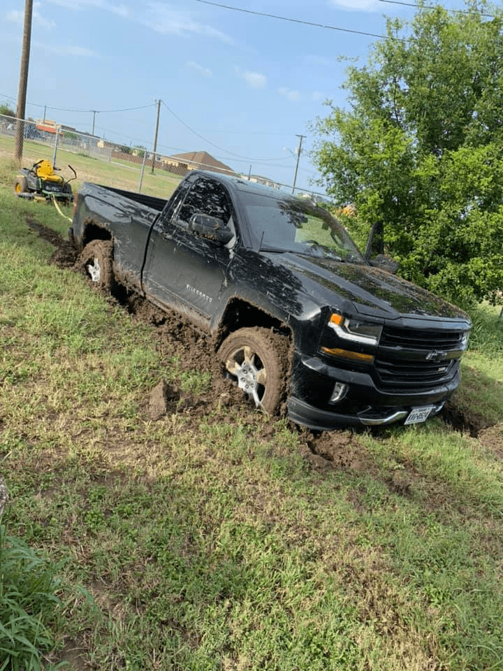 Chevrolet truck and John Deere Mower stuck in the mud 