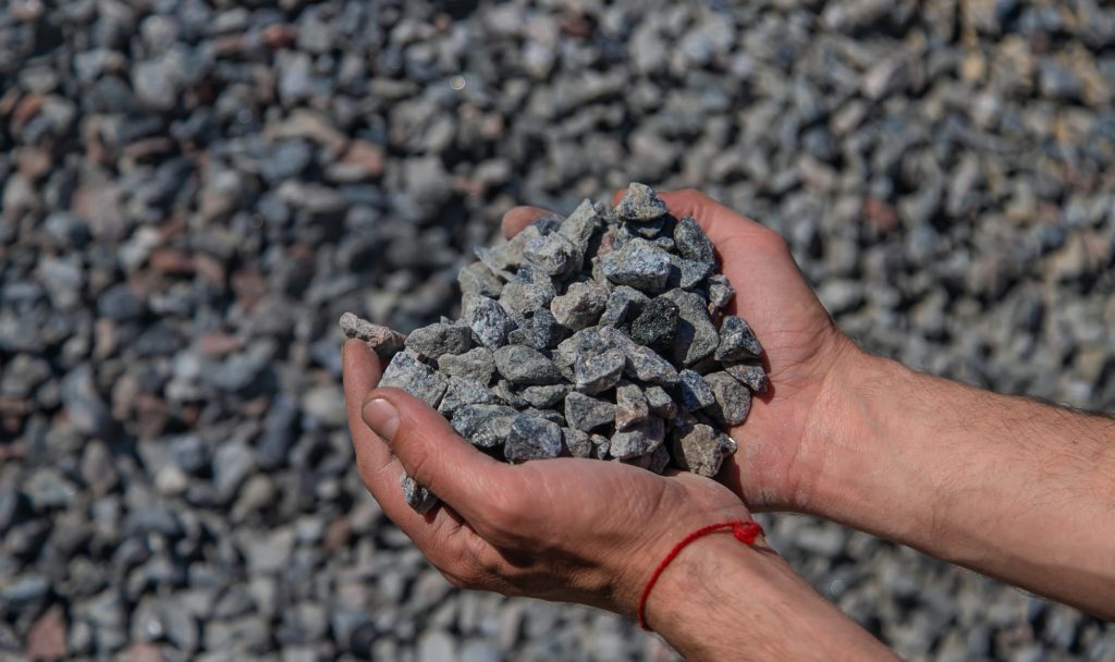 Crushed stones in the hands of a man. Selective focus.