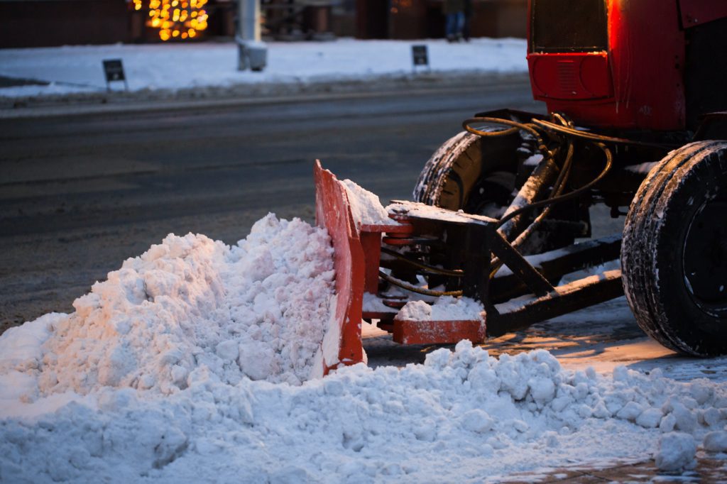 Tractor cleaning the road from the snow. Excavator cleans the streets of large amounts of snow in