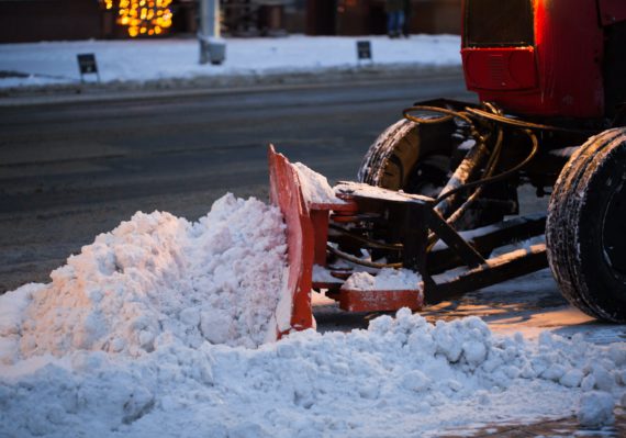 Tractor cleaning the road from the snow. Excavator cleans the streets of large amounts of snow in