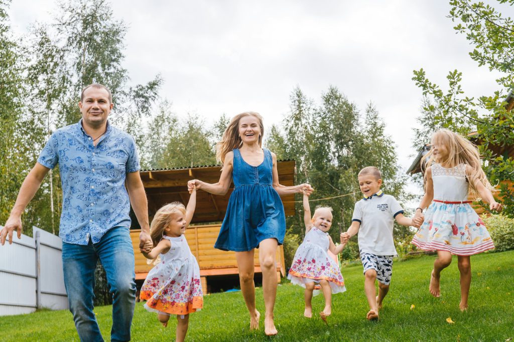 Happy family run and smile, summer backyard.