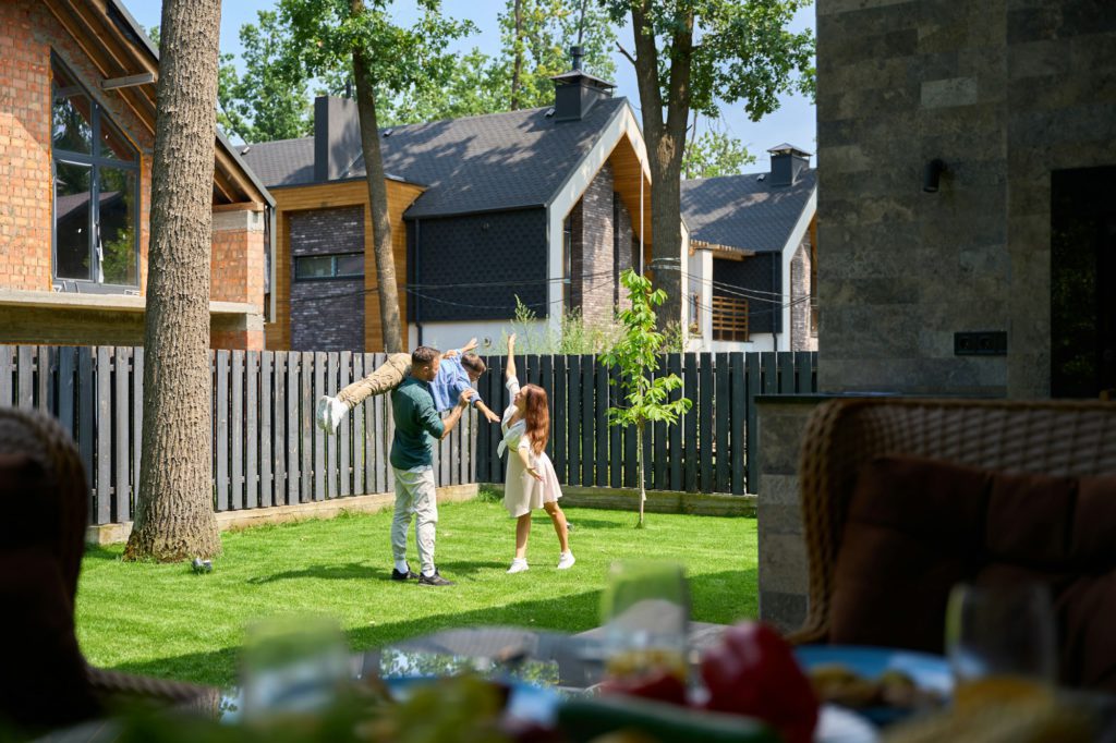 Parents play happily with their son on the lawn