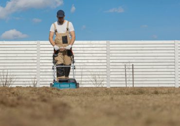 Scarifying lawn with scarifier, Man gardener scarifies the lawn and removal of old grass