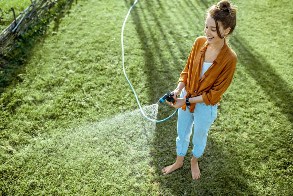 Woman watering green lawn